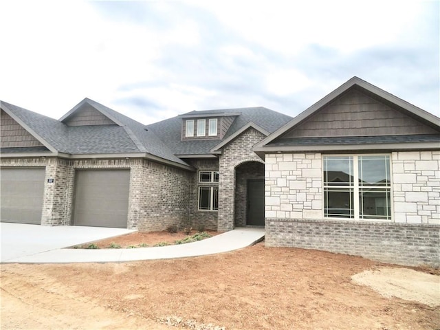 view of front of home featuring an attached garage, brick siding, driveway, and roof with shingles