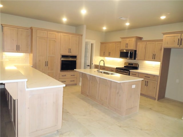 kitchen featuring marble finish floor, recessed lighting, light brown cabinetry, appliances with stainless steel finishes, and a sink