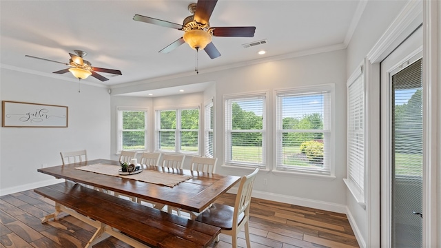 dining room with ornamental molding, plenty of natural light, and dark hardwood / wood-style floors