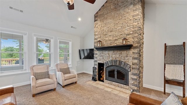 carpeted living room with a stone fireplace, high vaulted ceiling, and ceiling fan