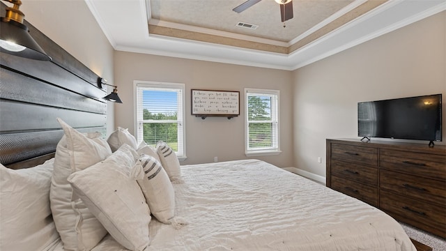 bedroom with a raised ceiling, crown molding, and ceiling fan