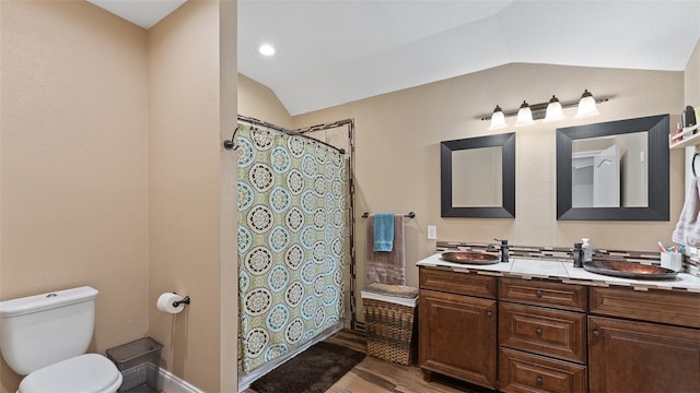 bathroom featuring toilet, vaulted ceiling, vanity, curtained shower, and hardwood / wood-style flooring