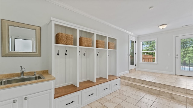 mudroom with ornamental molding, sink, and light tile patterned floors