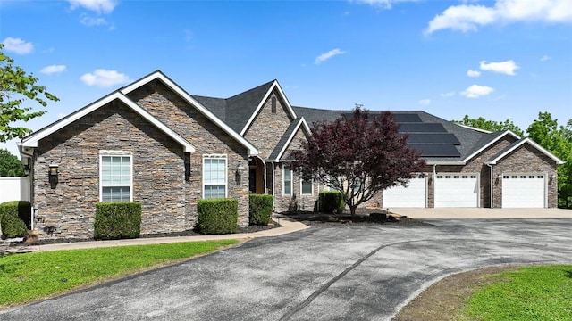 view of front facade with a garage and solar panels