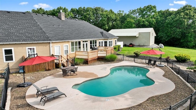 back of property featuring a pool side deck, a lawn, and a patio