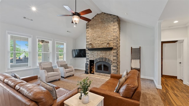 living room featuring high vaulted ceiling, a fireplace, ceiling fan, beam ceiling, and light hardwood / wood-style flooring