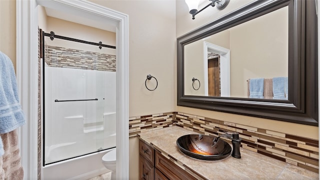 full bathroom featuring vanity, decorative backsplash, shower / bath combination with glass door, and toilet