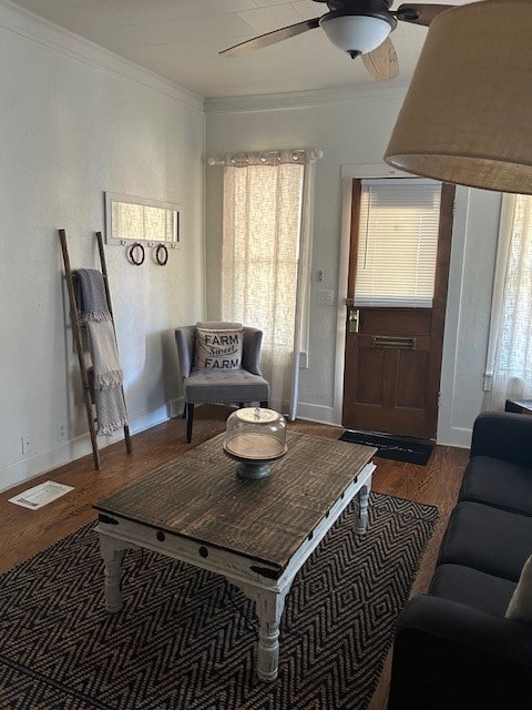 living room with dark hardwood / wood-style floors, ceiling fan, and crown molding