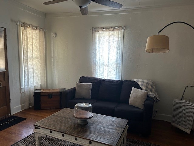 living room with ornamental molding, ceiling fan, and dark hardwood / wood-style flooring