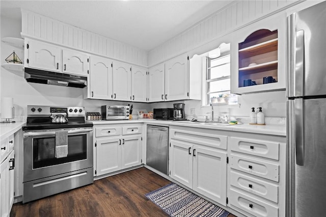 kitchen featuring light countertops, appliances with stainless steel finishes, dark wood-type flooring, white cabinets, and under cabinet range hood