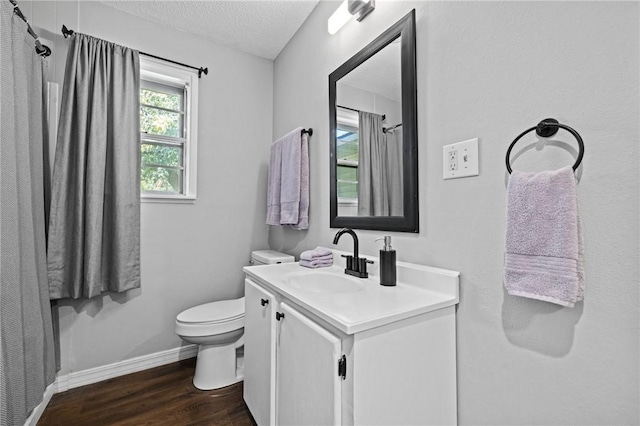 bathroom with baseboards, toilet, wood finished floors, a textured ceiling, and vanity