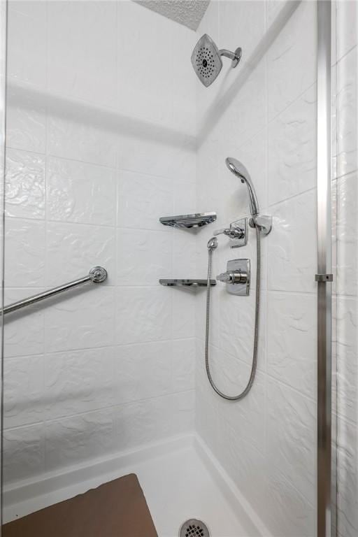 bathroom featuring a tile shower and a textured ceiling