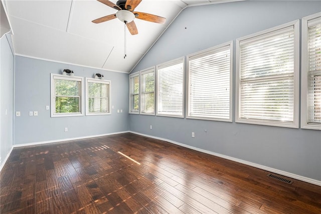 empty room featuring baseboards, visible vents, lofted ceiling, ceiling fan, and dark wood-style flooring