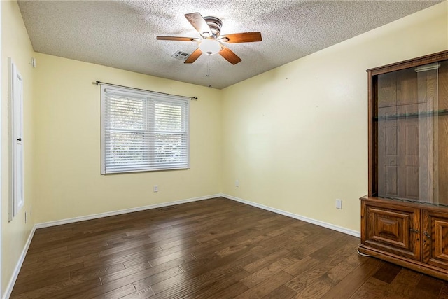 unfurnished bedroom with a textured ceiling, ceiling fan, dark wood-type flooring, and baseboards