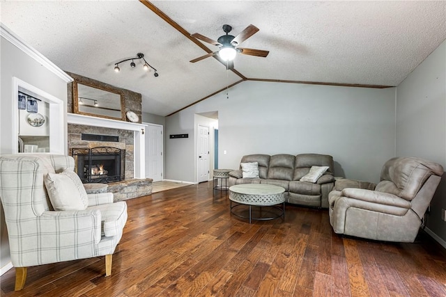 living room with crown molding, a fireplace, lofted ceiling, a textured ceiling, and wood finished floors