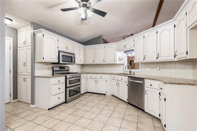 kitchen with stainless steel appliances, light stone countertops, and white cabinets