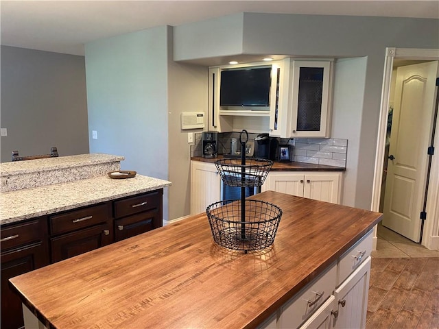 kitchen with tasteful backsplash, dark brown cabinets, white cabinets, and wood counters