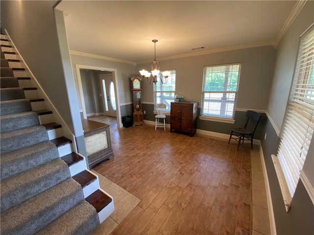 unfurnished dining area with crown molding, wood-type flooring, and an inviting chandelier