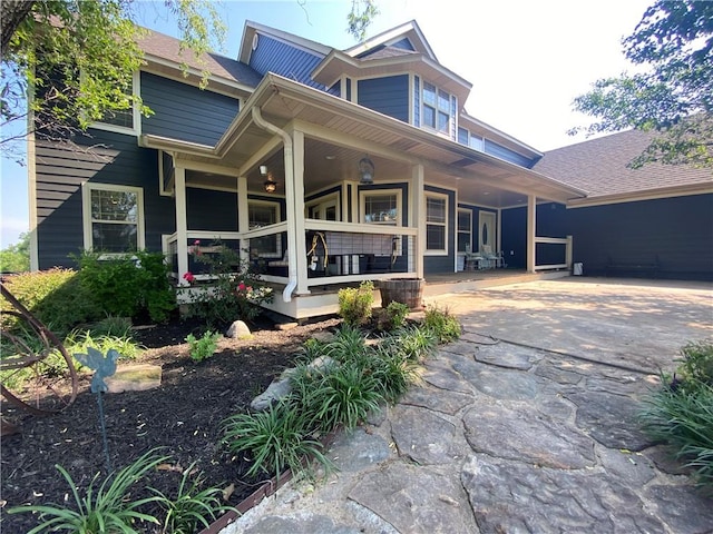 rear view of property featuring covered porch