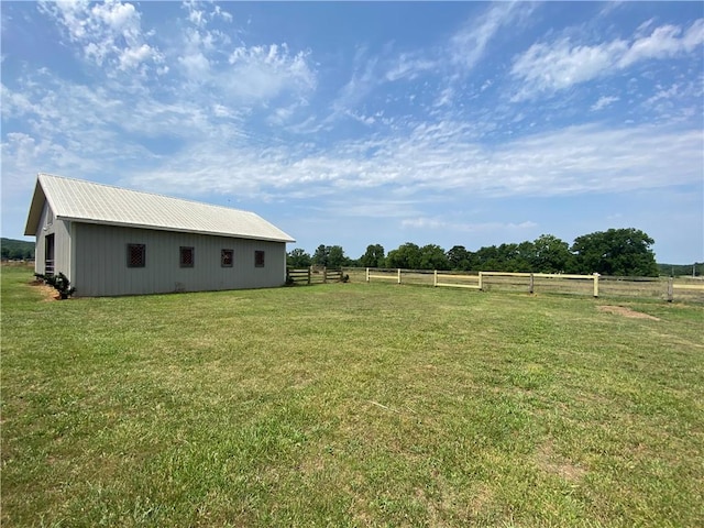 view of yard with an outdoor structure and a rural view