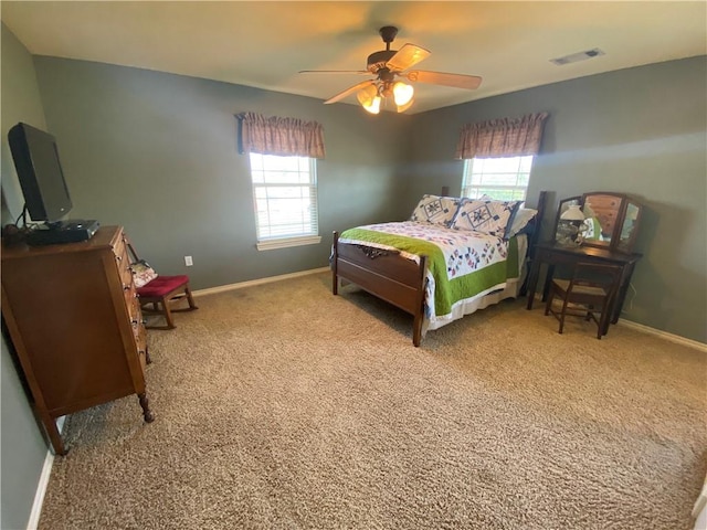 bedroom featuring multiple windows, light colored carpet, and ceiling fan