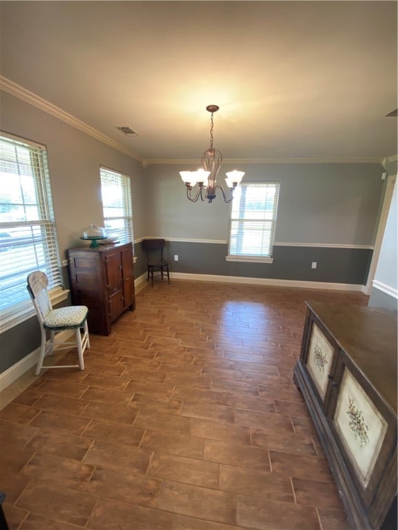 unfurnished dining area featuring ornamental molding, a chandelier, and plenty of natural light