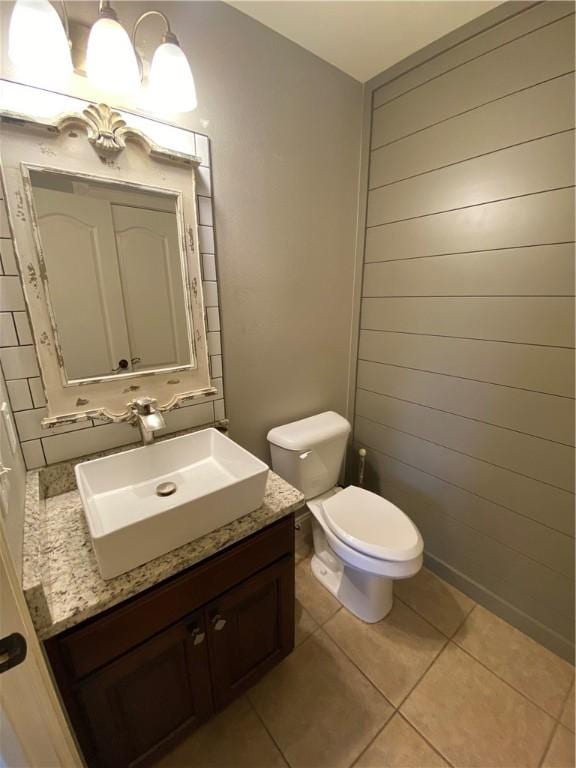 bathroom with tile patterned flooring, vanity, and toilet