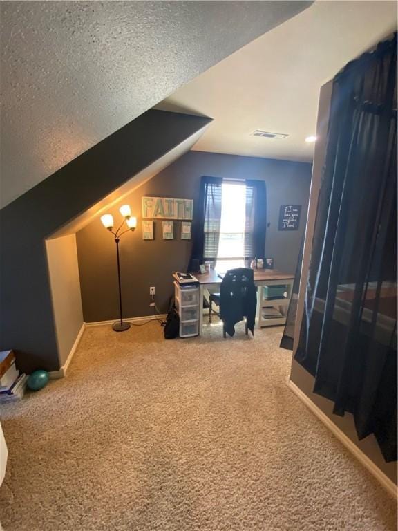 carpeted home office with lofted ceiling and a textured ceiling