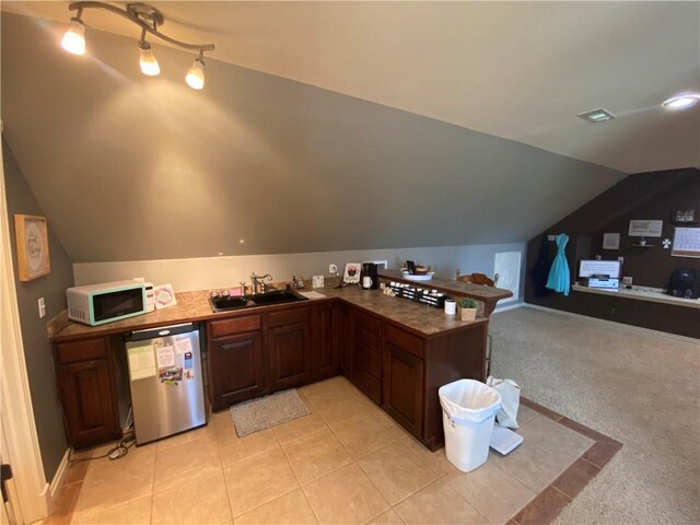 kitchen featuring sink, dishwasher, light carpet, vaulted ceiling, and kitchen peninsula