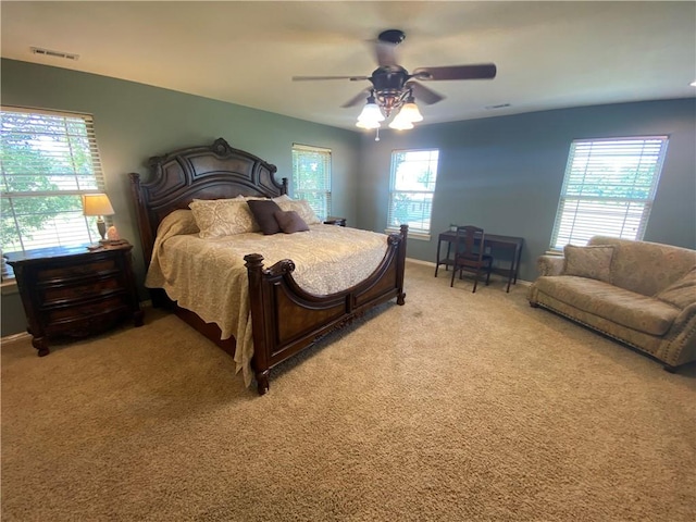 bedroom featuring multiple windows, ceiling fan, and carpet