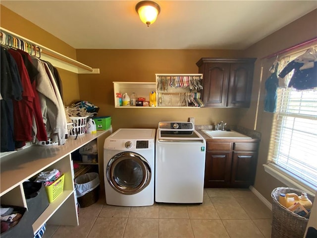 laundry room with cabinets, washing machine and dryer, sink, and light tile patterned flooring