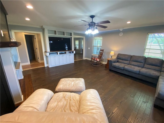 living room with dark wood-type flooring, ornamental molding, and ceiling fan