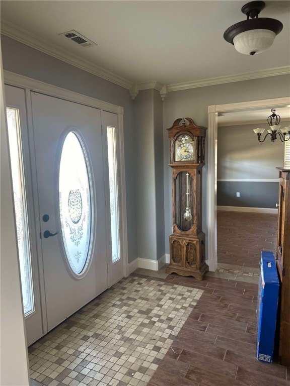 entrance foyer featuring a notable chandelier, crown molding, and a wealth of natural light