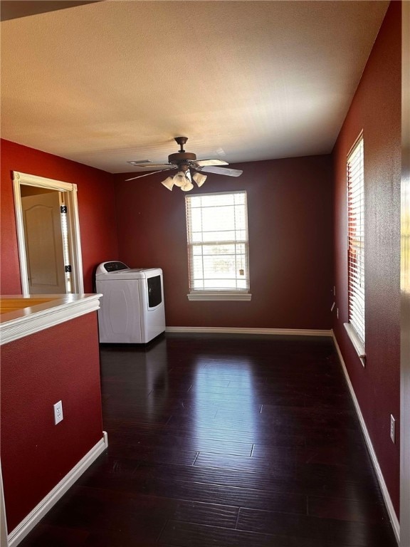 unfurnished room with washing machine and dryer, ceiling fan, and dark hardwood / wood-style flooring