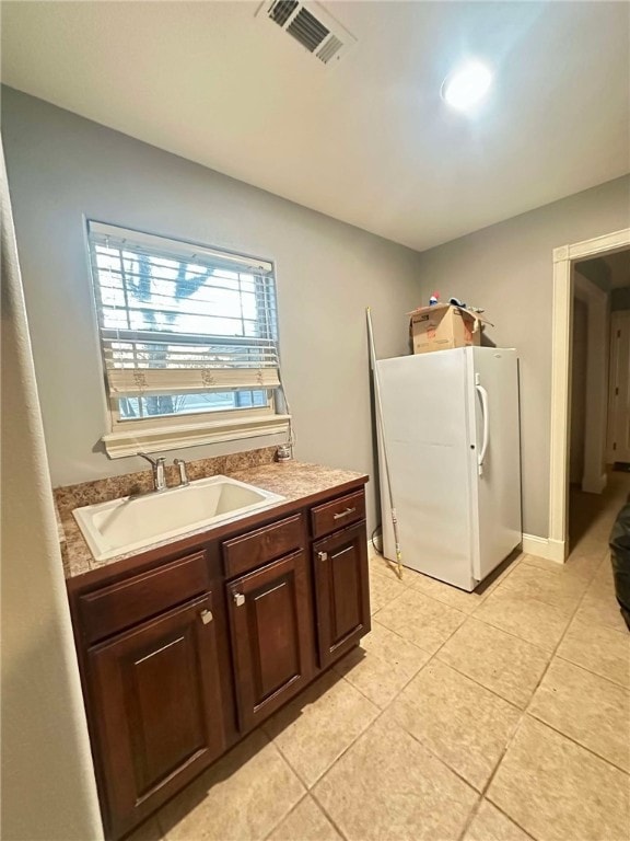 clothes washing area featuring sink and light tile patterned floors