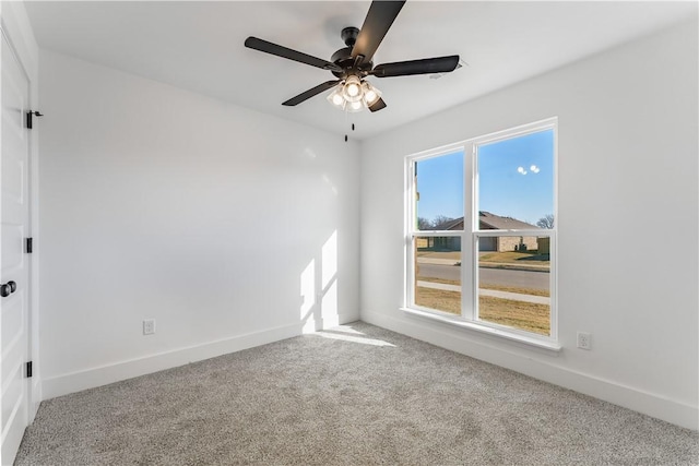 spare room featuring ceiling fan, a wealth of natural light, and carpet