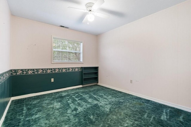 carpeted empty room featuring ceiling fan, visible vents, and baseboards