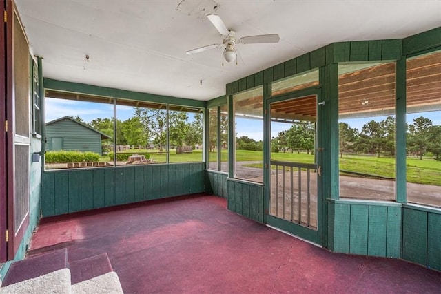 unfurnished sunroom featuring a ceiling fan