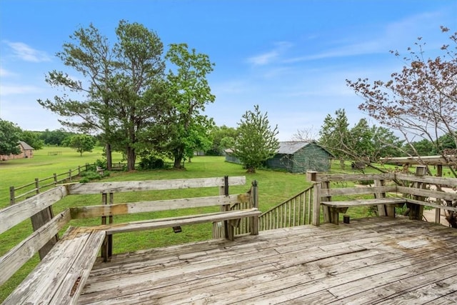 wooden deck with a rural view and a lawn