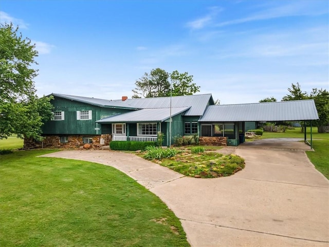 split level home featuring a porch, a front yard, concrete driveway, and metal roof