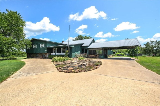 view of front facade featuring covered porch, concrete driveway, an attached carport, and a front yard