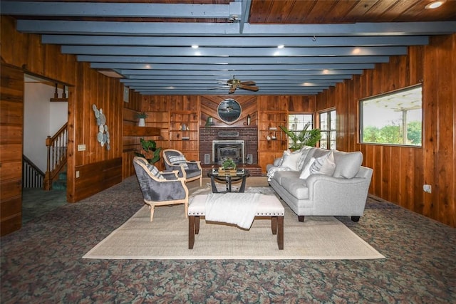 carpeted living area featuring stairs, beamed ceiling, and wood walls