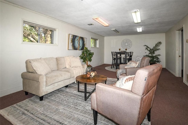 living area with a wealth of natural light, carpet flooring, and visible vents