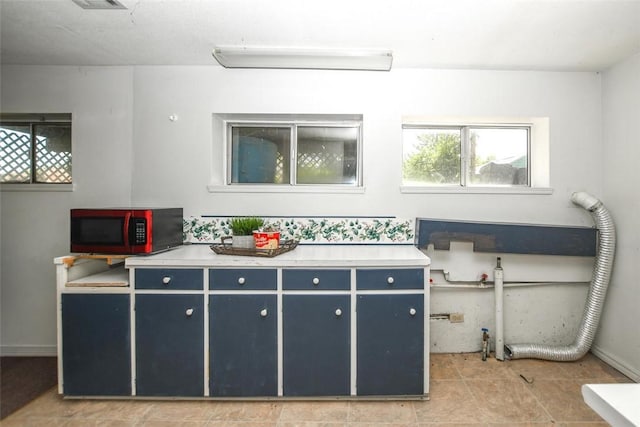 kitchen with light countertops and blue cabinetry