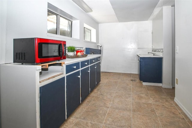 kitchen with blue cabinets, light countertops, and a sink