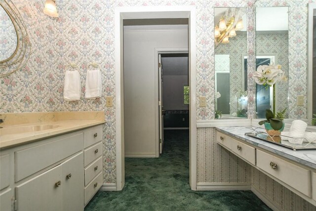 bathroom with vanity, baseboards, and wallpapered walls