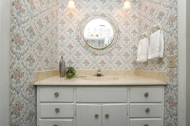 bathroom with vanity and wallpapered walls