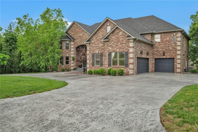 view of front of house featuring a garage, brick siding, a shingled roof, concrete driveway, and a front yard