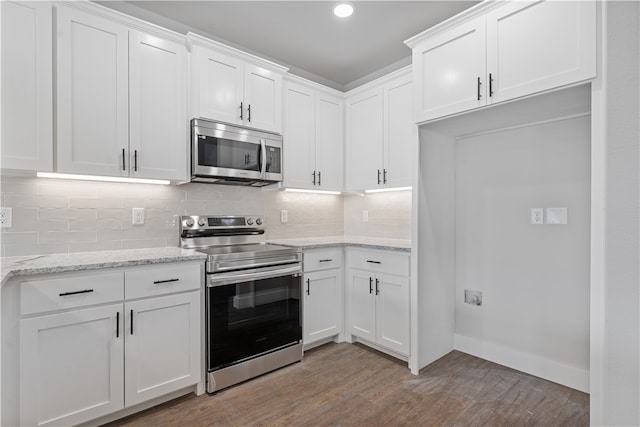 kitchen featuring appliances with stainless steel finishes, white cabinetry, and light hardwood / wood-style floors