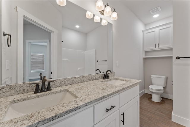 bathroom with toilet, hardwood / wood-style floors, and vanity